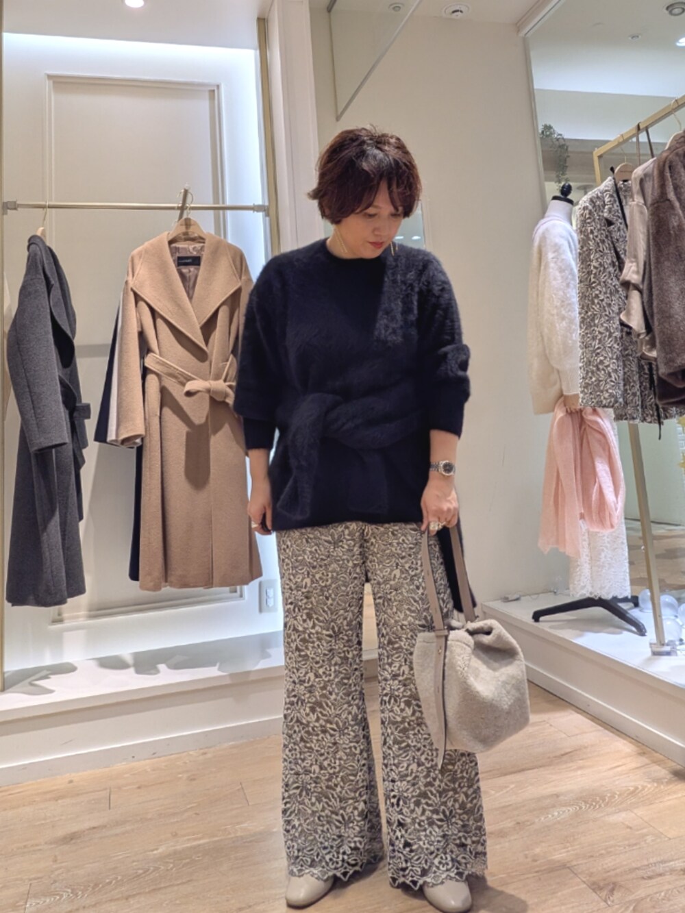 ブラック系のニット/セーター、ベージュ系のその他パンツ、ベージュ系のショルダーバッグを着用したレディースの冬コーディネートの2枚目の写真