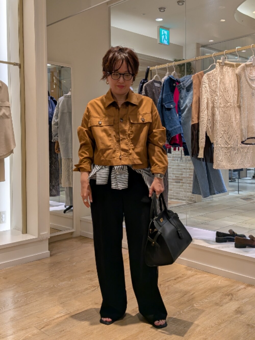 イエロー系のブルゾン、ブルー系のシャツ/ブラウス、ブラック系のその他パンツを着用したレディースの秋コーディネートの2枚目の写真