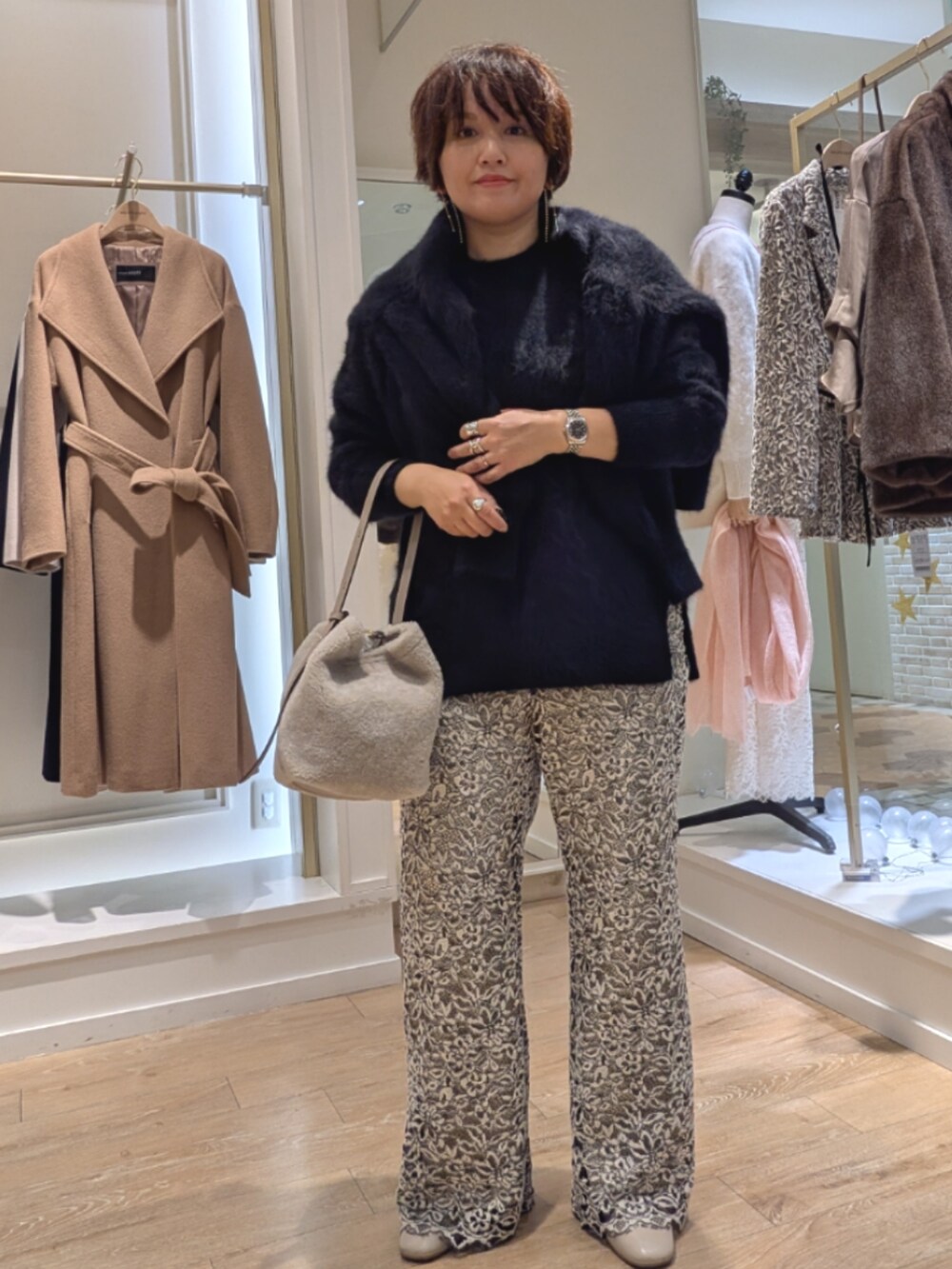 ブラック系のニット/セーター、ベージュ系のその他パンツ、ベージュ系のショルダーバッグを着用したレディースの冬コーディネートの4枚目の写真