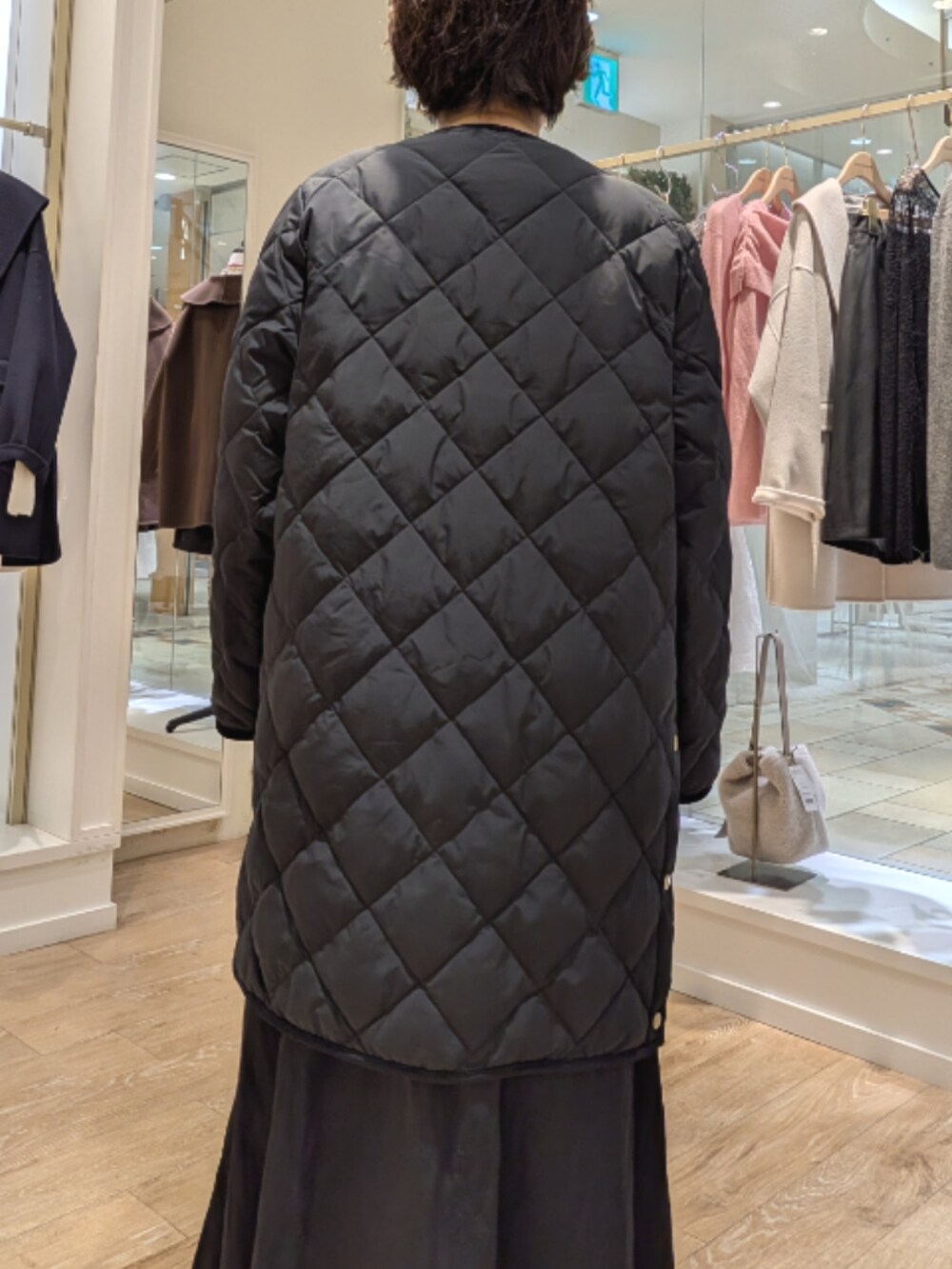 ブラック系のダウンジャケット/コート、ブラック系のワンピース、ホワイト系のシャツ/ブラウスを着用したレディースの秋コーディネートの6枚目の写真