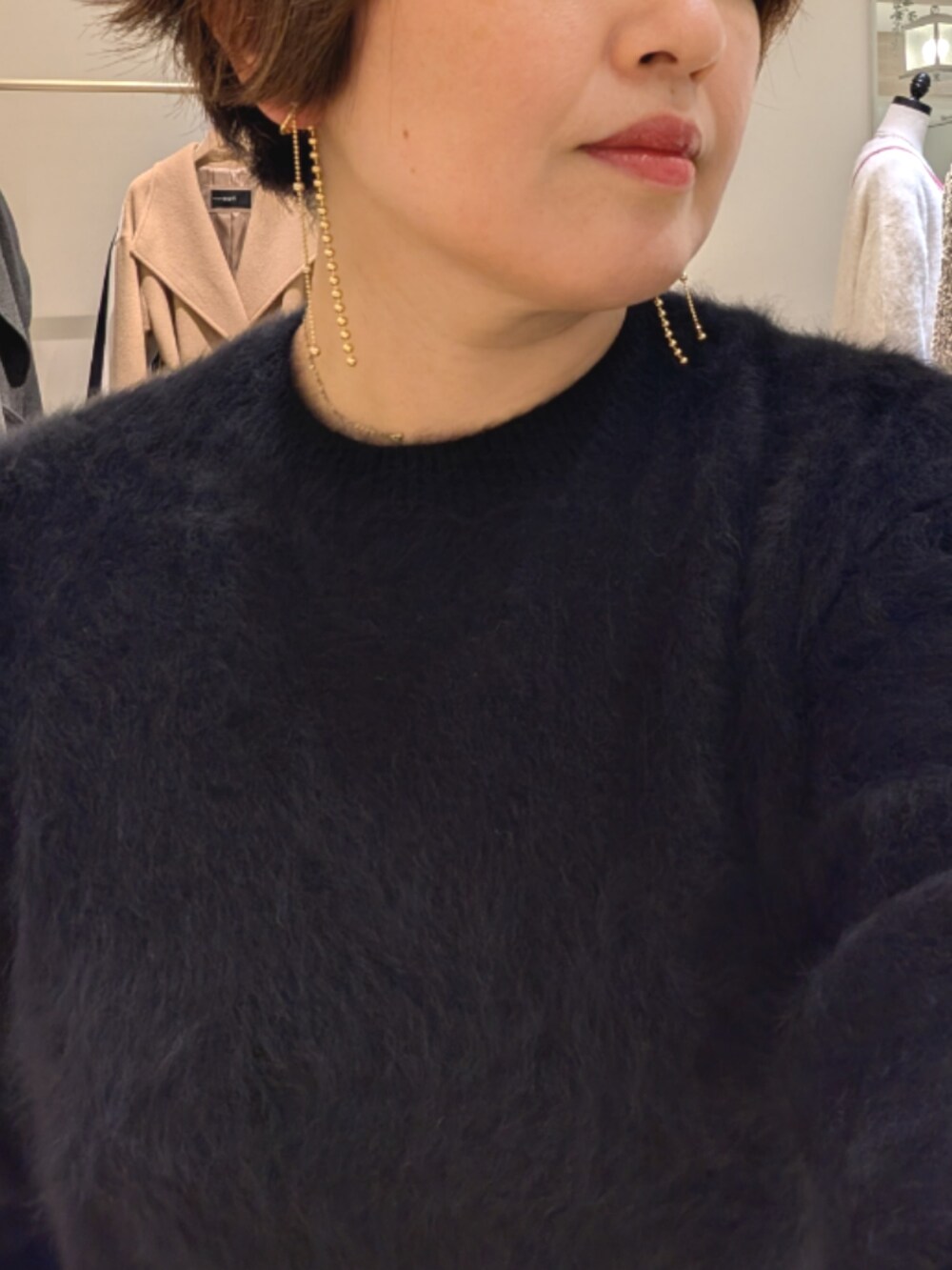 ブラック系のニット/セーター、ベージュ系のその他パンツ、ベージュ系のショルダーバッグを着用したレディースの冬コーディネートの7枚目の写真