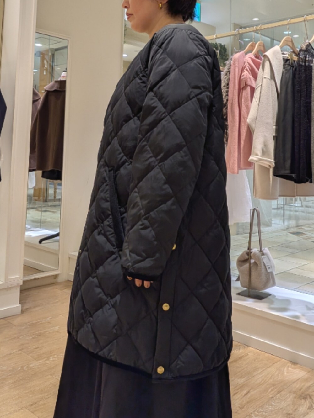 ブラック系のダウンジャケット/コート、ブラック系のワンピース、ホワイト系のシャツ/ブラウスを着用したレディースの秋コーディネートの5枚目の写真