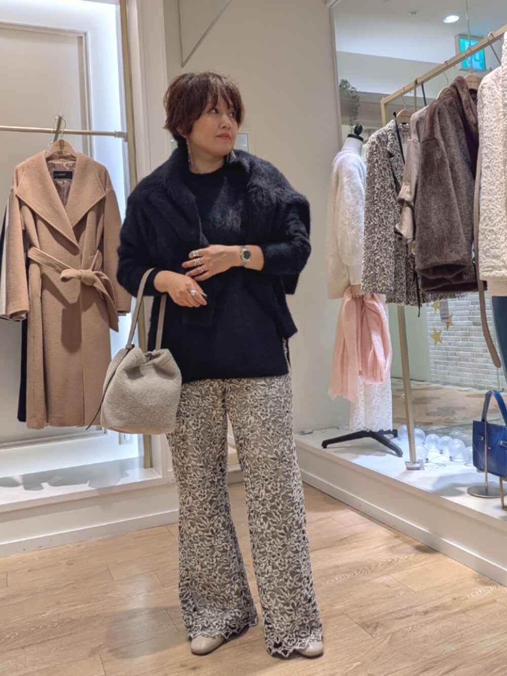 ブラック系のニット/セーター、ベージュ系のその他パンツ、ベージュ系のショルダーバッグを着用したレディースの冬コーディネートの3枚目の写真