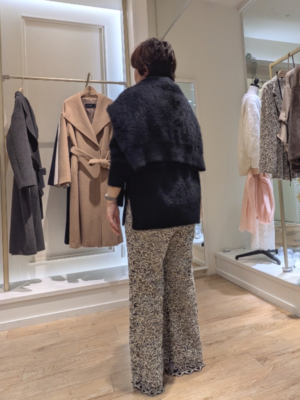 ブラック系のニット/セーター、ベージュ系のその他パンツ、ベージュ系のショルダーバッグを着用したレディースの冬コーディネートの6枚目の写真