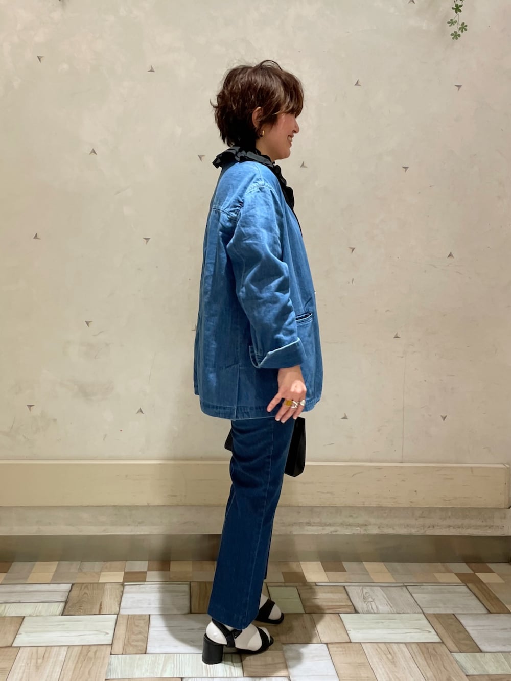 ブラック系のシャツ/ブラウス、ブルー系のデニムパンツ、ブラック系のショルダーバッグを着用したレディースの春コーディネートの2枚目の写真