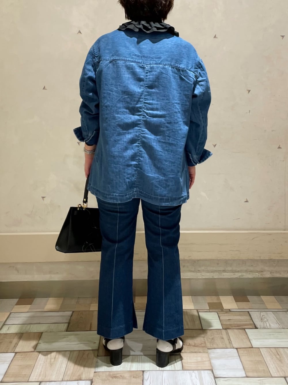 ブラック系のシャツ/ブラウス、ブルー系のデニムパンツ、ブラック系のショルダーバッグを着用したレディースの春コーディネートの3枚目の写真