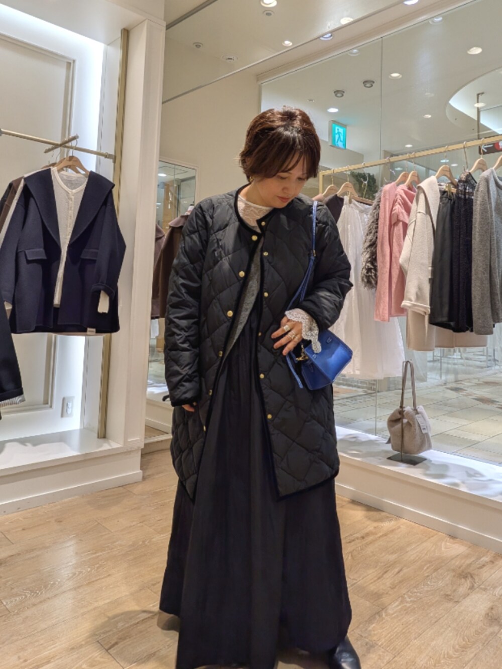 ブラック系のダウンジャケット/コート、ブラック系のワンピース、ホワイト系のシャツ/ブラウスを着用したレディースの秋コーディネートの3枚目の写真