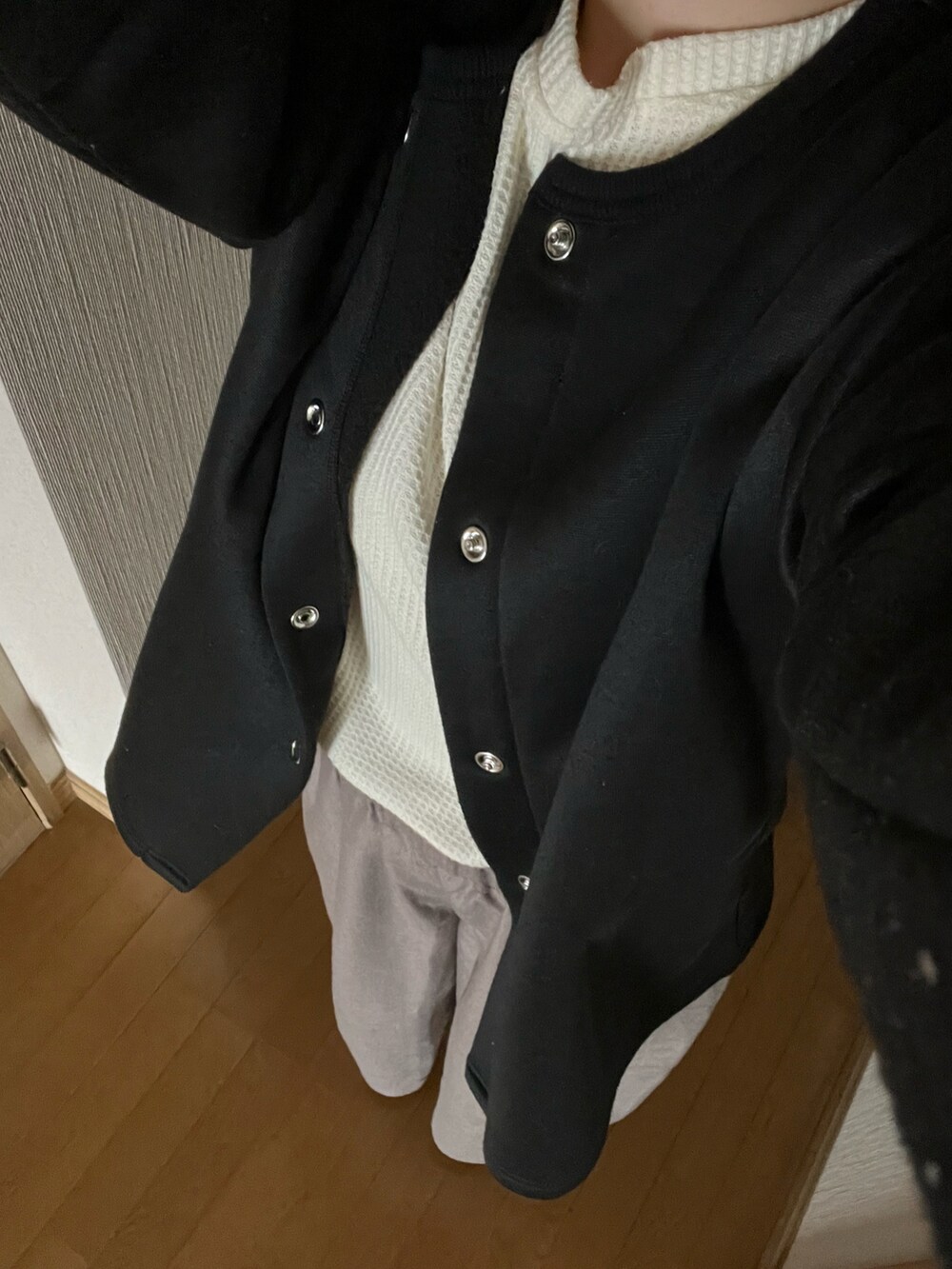 グレー系のスカート、ブラウン系のバッグを着用したレディースの冬コーディネートの2枚目の写真