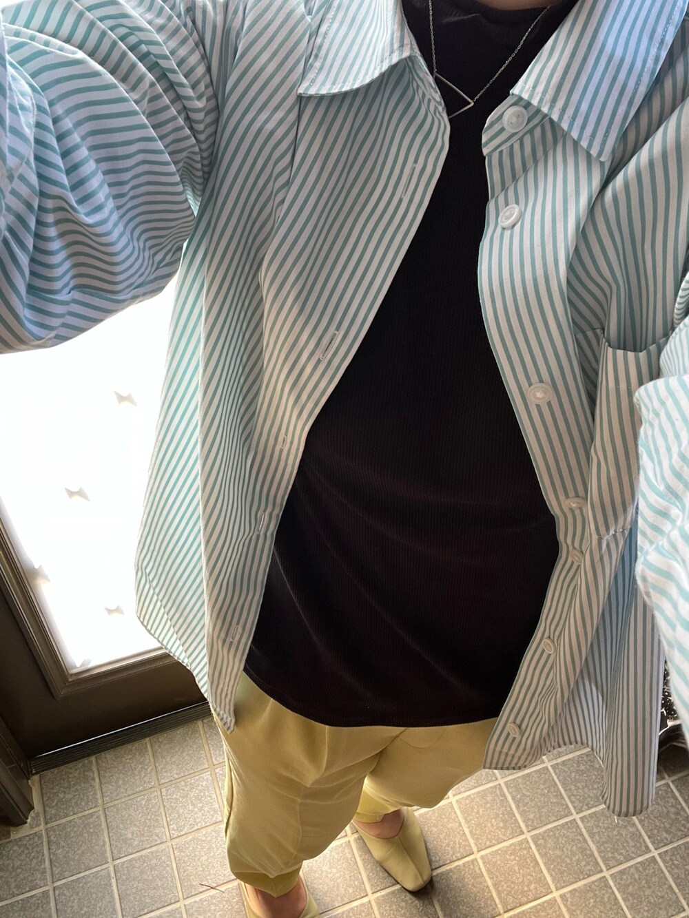 グリーン系のシャツ/ブラウス、ベージュ系のベスト、グリーン系のパンツを着用したレディースの春コーディネートの2枚目の写真