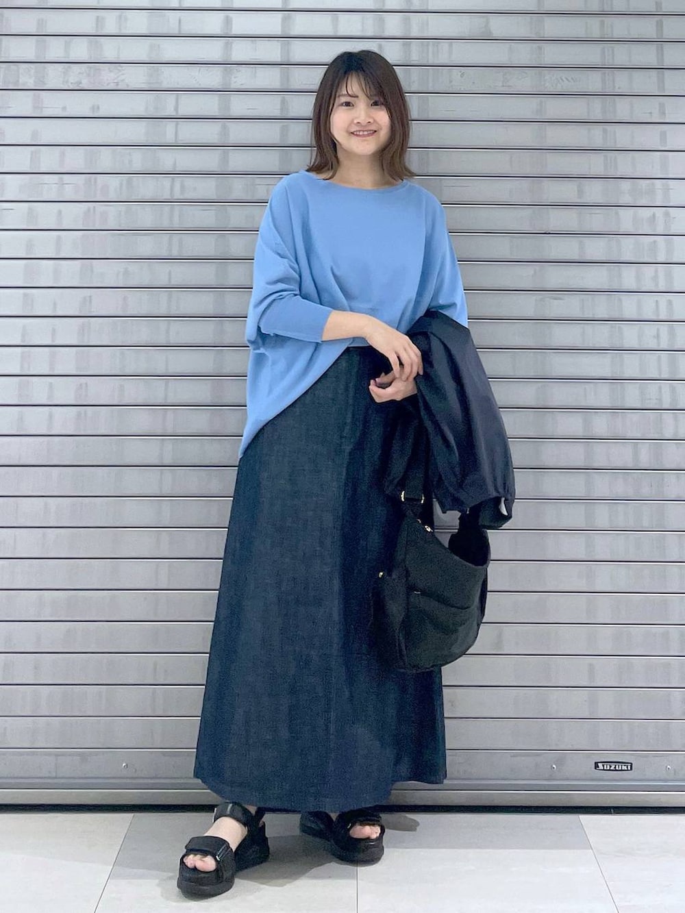ブラック系のボディバッグ/ウエストポーチ、ブラック系のサンダル、ブルー系のスカートを着用したレディースの春コーディネートの4枚目の写真