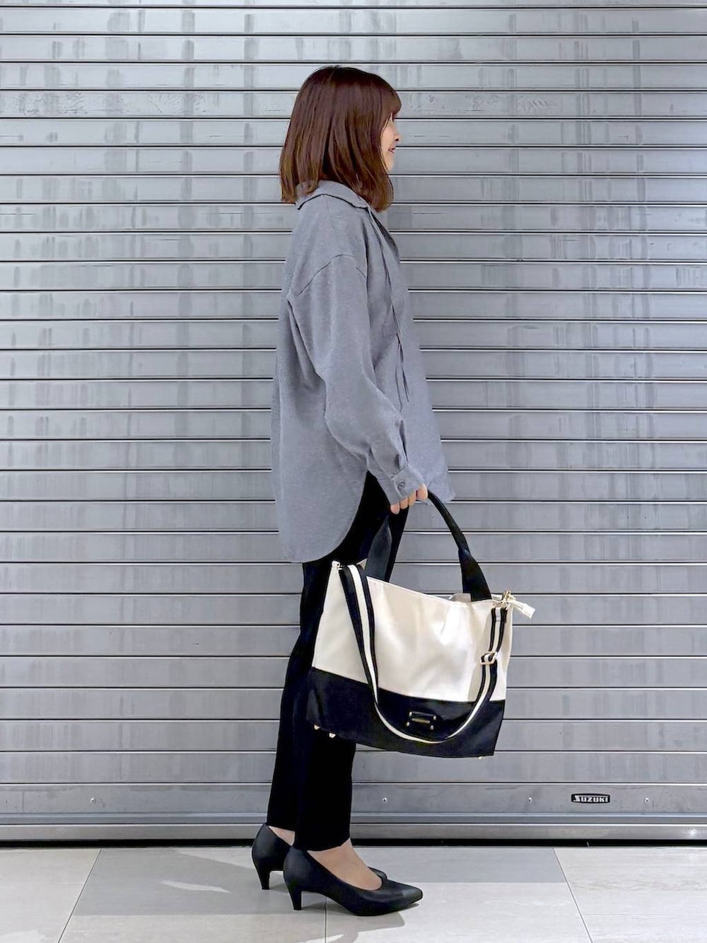 ブラック系のパンプス、ホワイト系のTシャツ/カットソー、グレー系のシャツ/ブラウスを着用したレディースの秋コーディネートの2枚目の写真