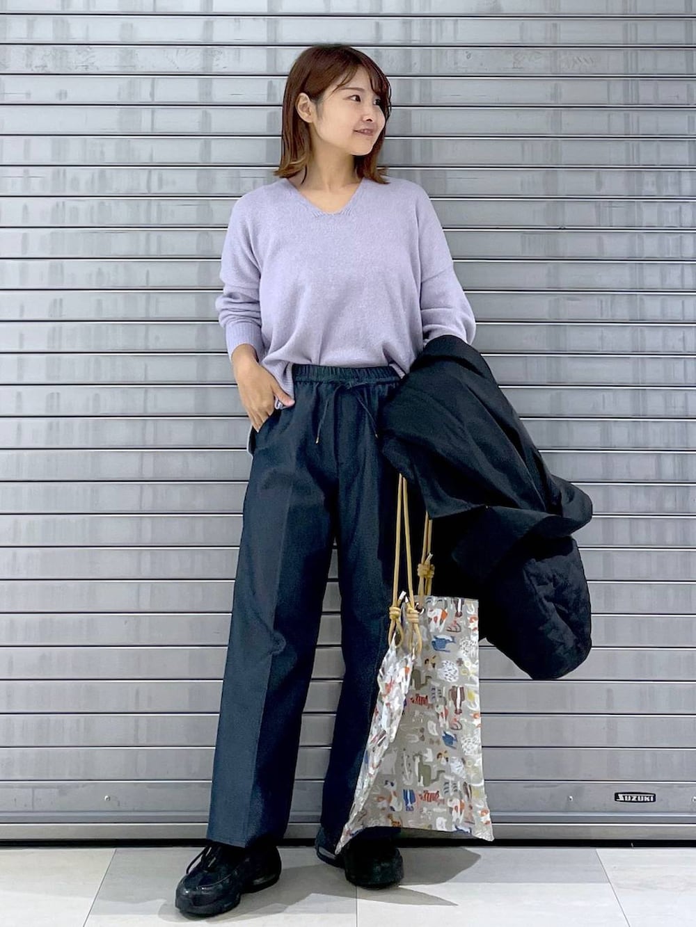 パープル系のニット/セーター、ベージュ系のトートバッグ、ブルー系のデニムパンツを着用したレディースの秋コーディネートの4枚目の写真