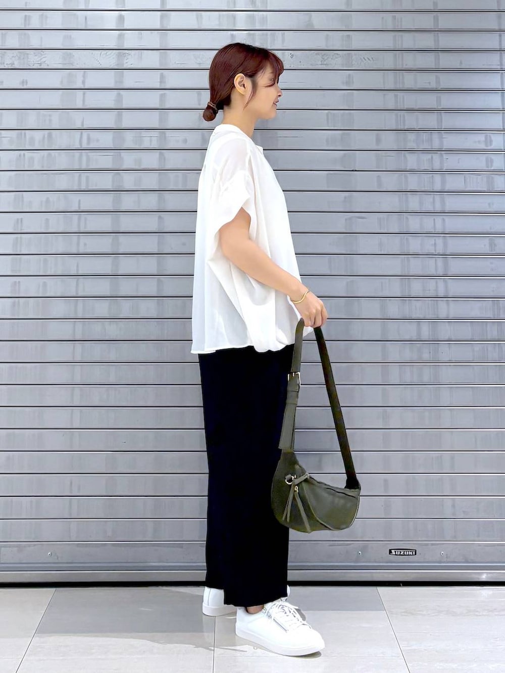 グリーン系のハンドバッグ、ブラック系のその他パンツ、ホワイト系のTシャツ/カットソーを着用したレディースの夏コーディネートの3枚目の写真