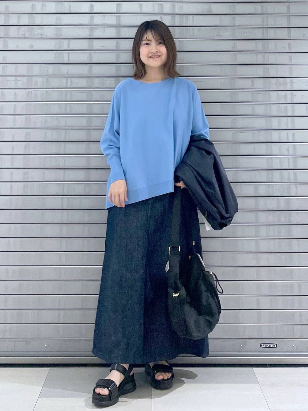ブラック系のボディバッグ/ウエストポーチ、ブラック系のサンダル、ブルー系のスカートを着用したレディースの春コーディネートの5枚目の写真