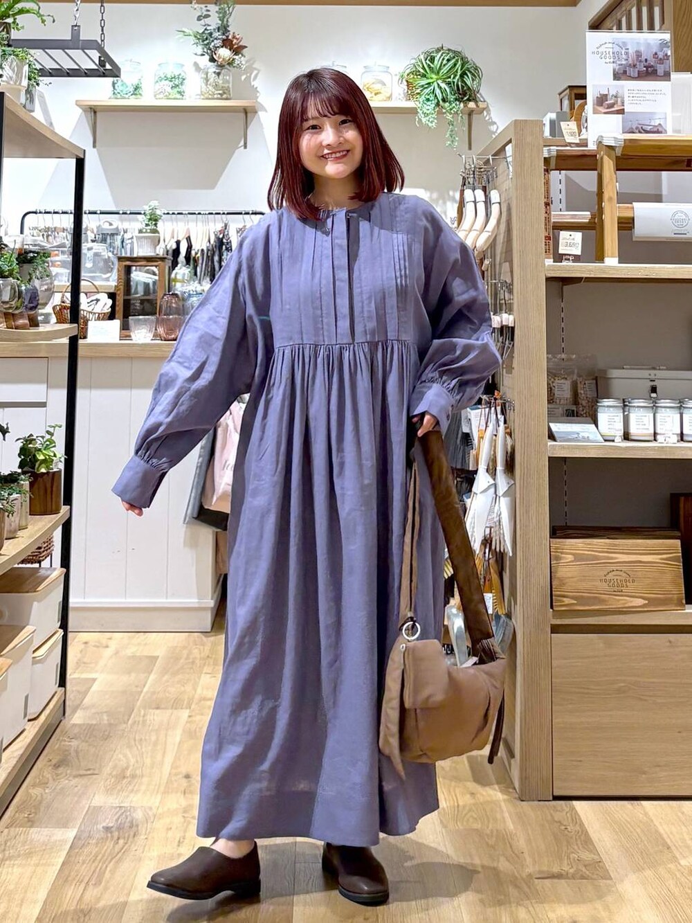 ブラウン系のショルダーバッグ、ブルー系のワンピースを着用したレディースの冬コーディネートの4枚目の写真