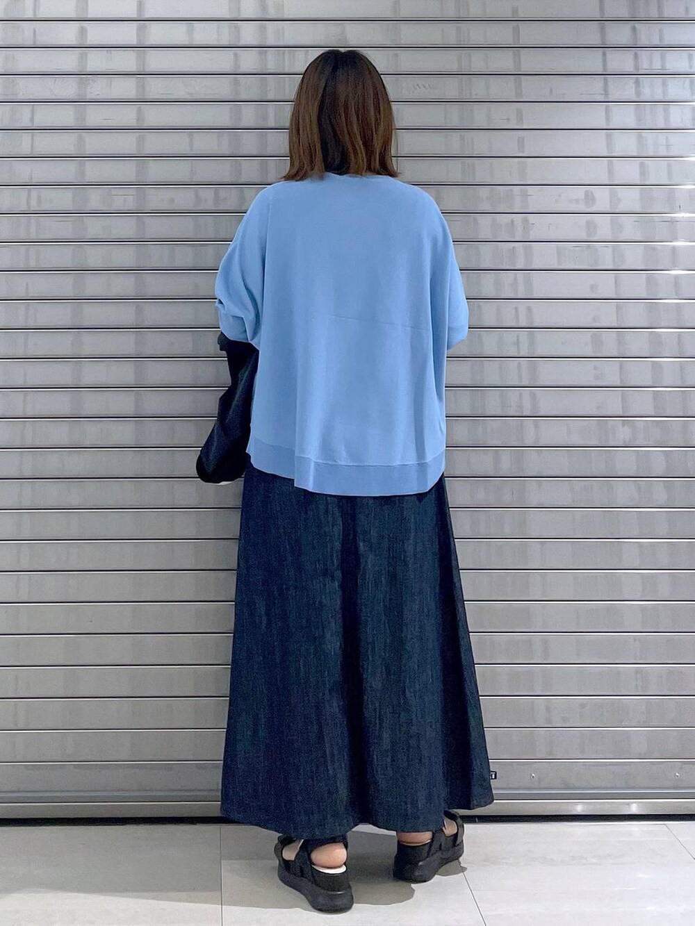 ブラック系のボディバッグ/ウエストポーチ、ブラック系のサンダル、ブルー系のスカートを着用したレディースの春コーディネートの8枚目の写真