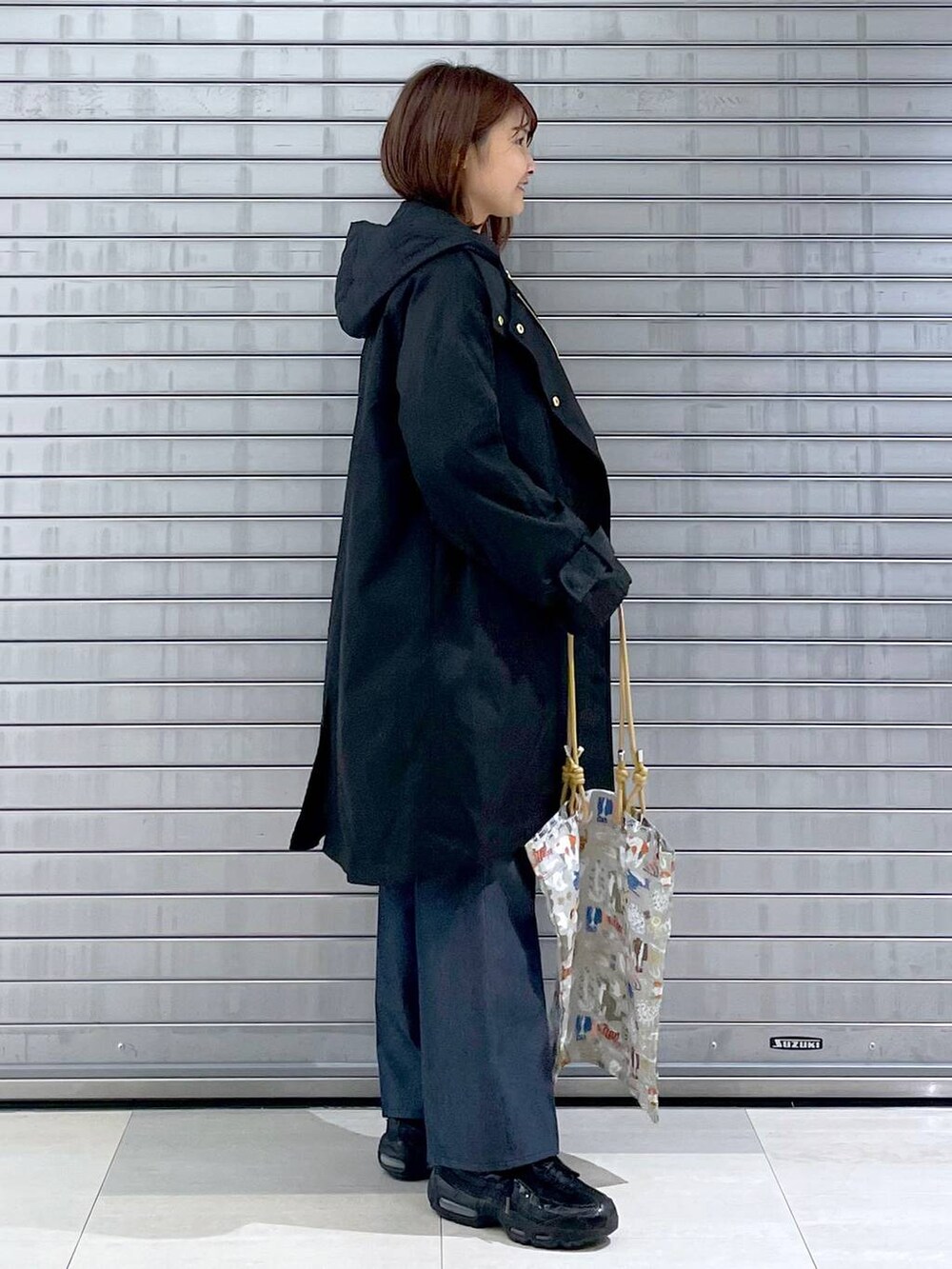 パープル系のニット/セーター、ベージュ系のトートバッグ、ブルー系のデニムパンツを着用したレディースの秋コーディネートの2枚目の写真