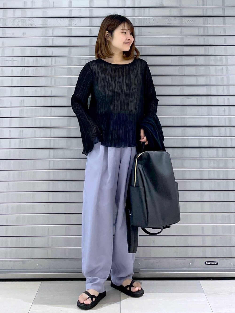 ブラック系のカーディガン/ボレロ、ブラック系のバックパック/リュック、ブラック系のシャツ/ブラウスを着用したレディースの春コーディネートの2枚目の写真