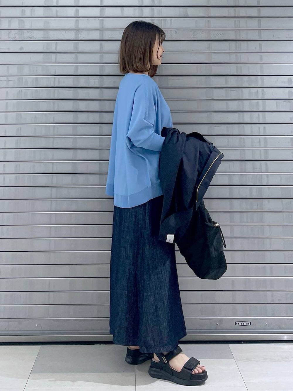 ブラック系のボディバッグ/ウエストポーチ、ブラック系のサンダル、ブルー系のスカートを着用したレディースの春コーディネートの7枚目の写真