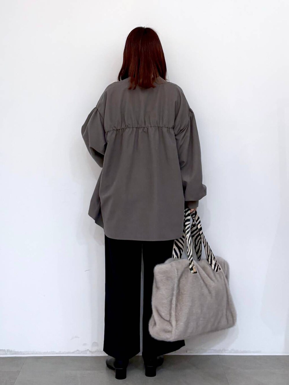 ブラック系のブーツ、ブルー系のその他パンツ、グレー系のトートバッグを着用したレディースの冬コーディネートの3枚目の写真