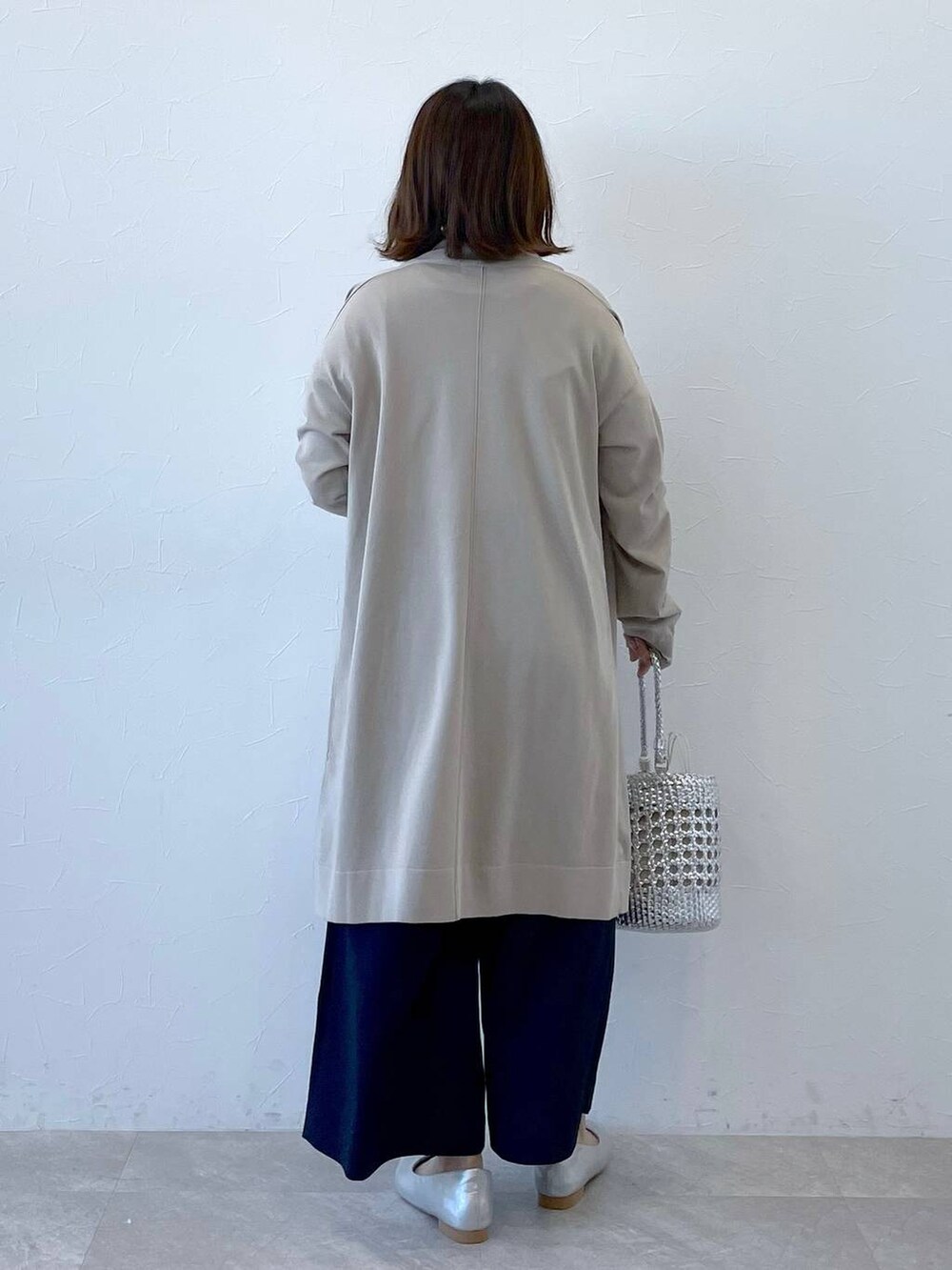 ベージュ系のカーディガン/ボレロ、シルバー系のパンプス、ホワイト系のTシャツ/カットソーを着用したレディースの春コーディネートの3枚目の写真