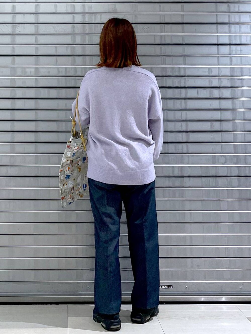 パープル系のニット/セーター、ベージュ系のトートバッグ、ブルー系のデニムパンツを着用したレディースの秋コーディネートの7枚目の写真