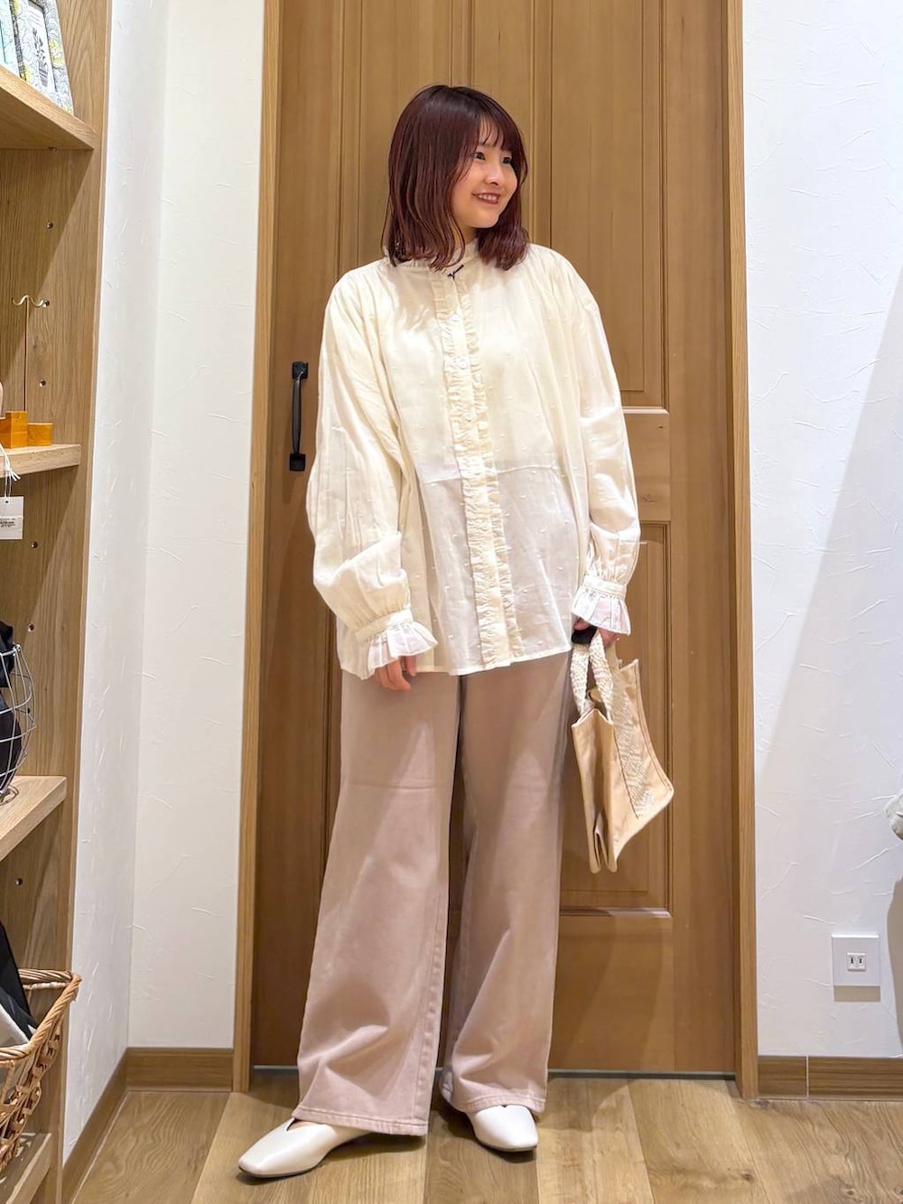 ベージュ系のデニムパンツ、ホワイト系のシャツ/ブラウス、ベージュ系のトートバッグを着用したレディースの春コーディネートの2枚目の写真