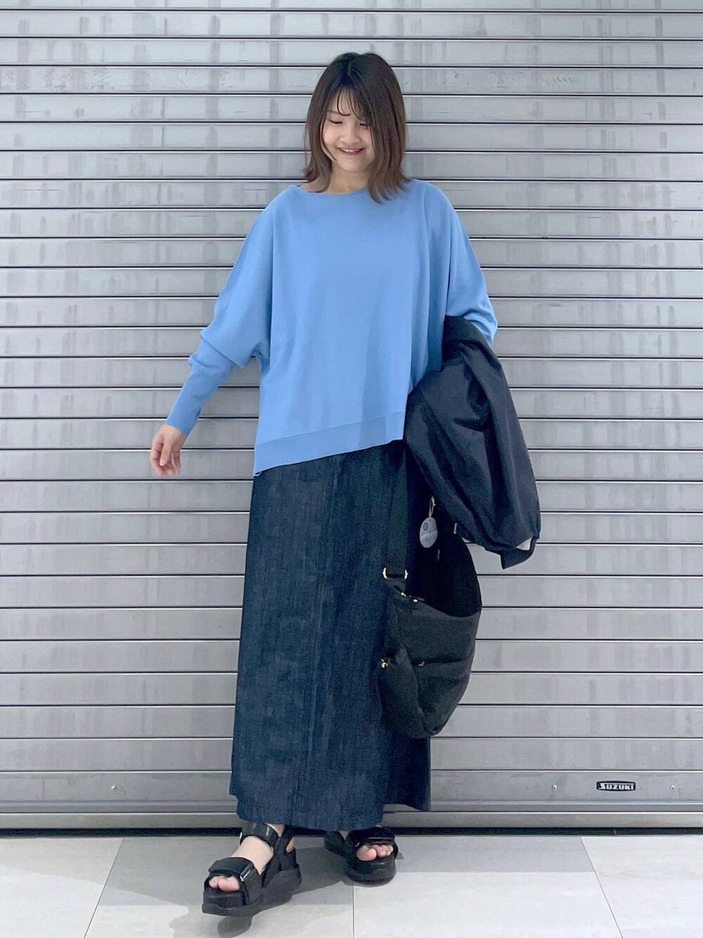 ブラック系のボディバッグ/ウエストポーチ、ブラック系のサンダル、ブルー系のスカートを着用したレディースの春コーディネートの6枚目の写真