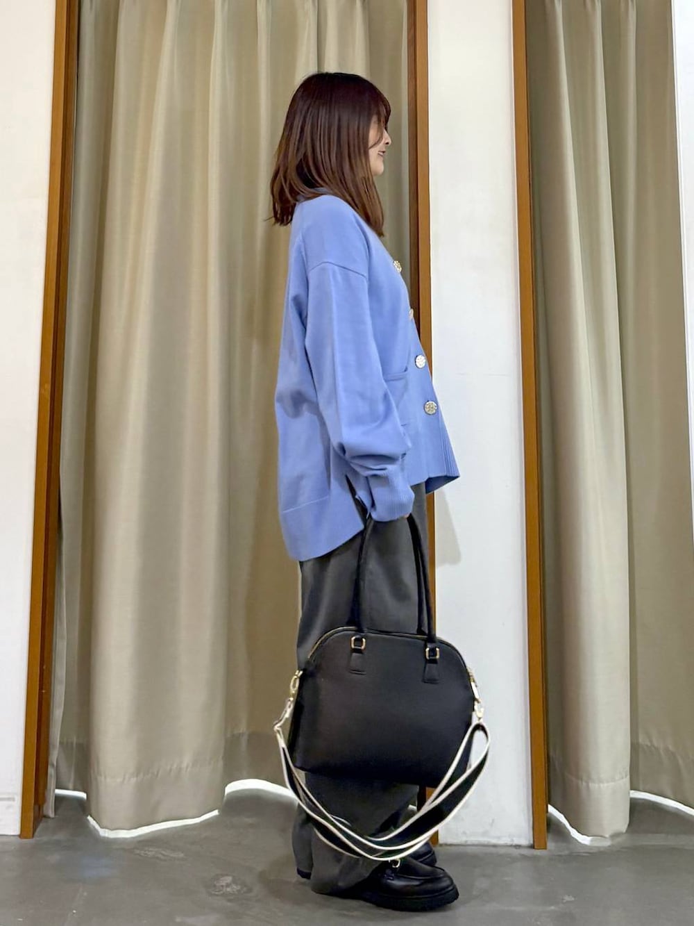 ブラック系のタンクトップ、ブラック系のハンドバッグ、ブラック系のローファーを着用したレディースの冬コーディネートの2枚目の写真