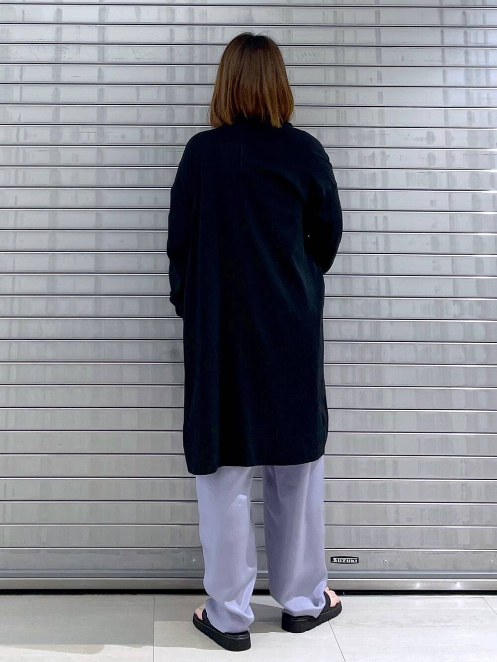 ブラック系のカーディガン/ボレロ、ブラック系のバックパック/リュック、ブラック系のシャツ/ブラウスを着用したレディースの春コーディネートの6枚目の写真