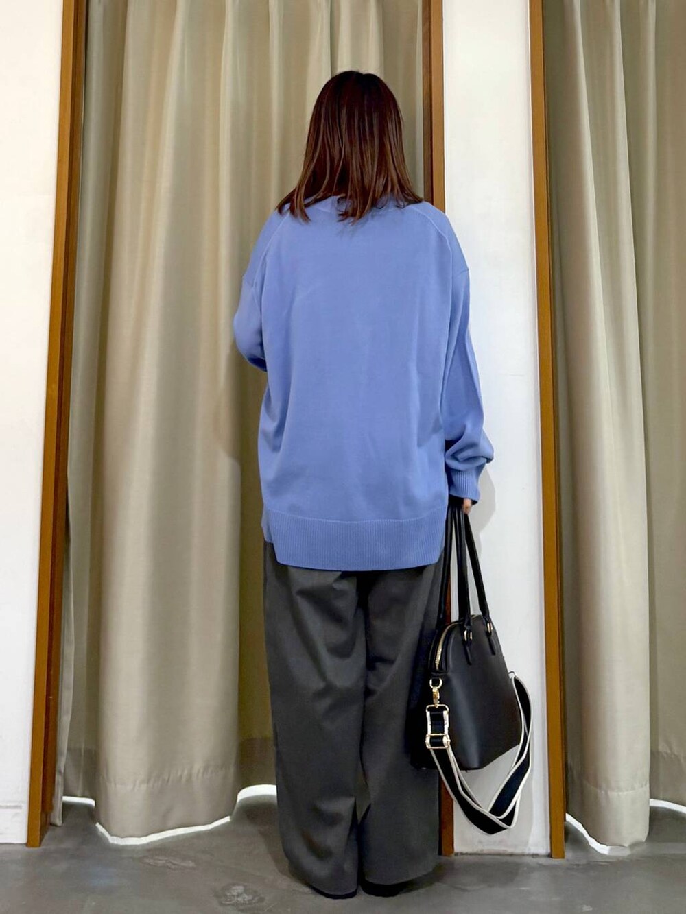 ブラック系のタンクトップ、ブラック系のハンドバッグ、ブラック系のローファーを着用したレディースの冬コーディネートの3枚目の写真