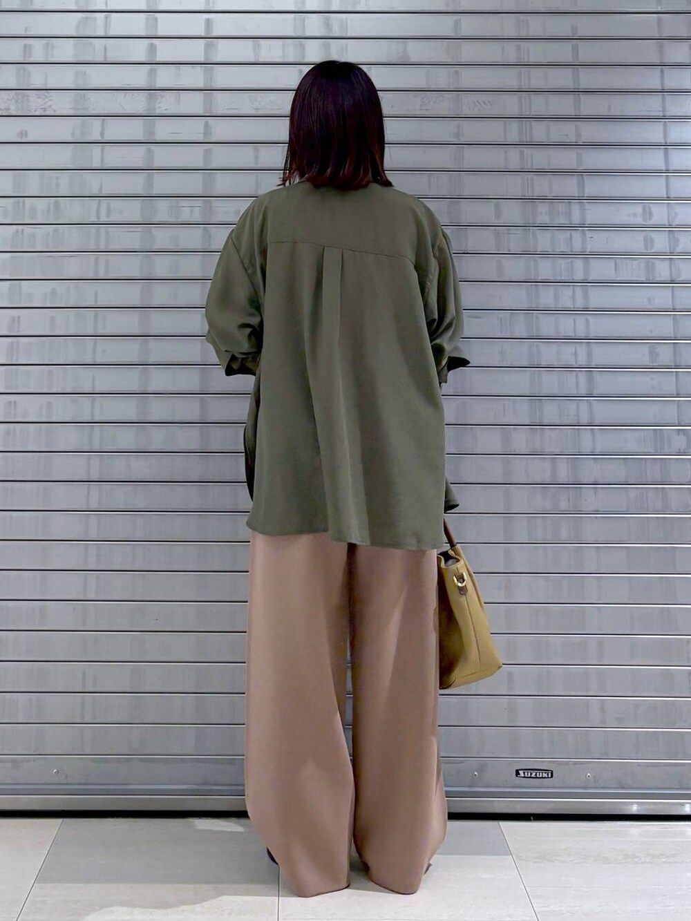 ゴールド系のサンダル、ベージュ系のハンドバッグ、ブラウン系のその他パンツを着用したレディースの秋コーディネートの6枚目の写真