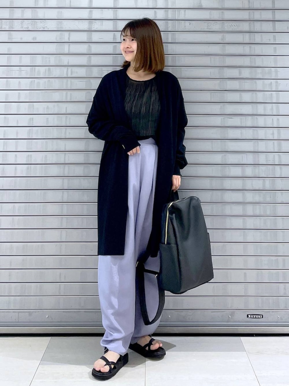 ブラック系のカーディガン/ボレロ、ブラック系のバックパック/リュック、ブラック系のシャツ/ブラウスを着用したレディースの春コーディネートの4枚目の写真