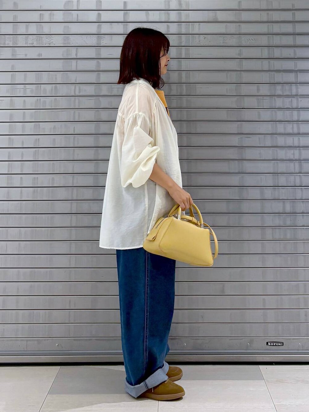 ブルー系のサロペット/オーバーオール、オレンジ系のTシャツ/カットソー、ホワイト系のカーディガン/ボレロを着用したレディースの秋コーディネートの5枚目の写真