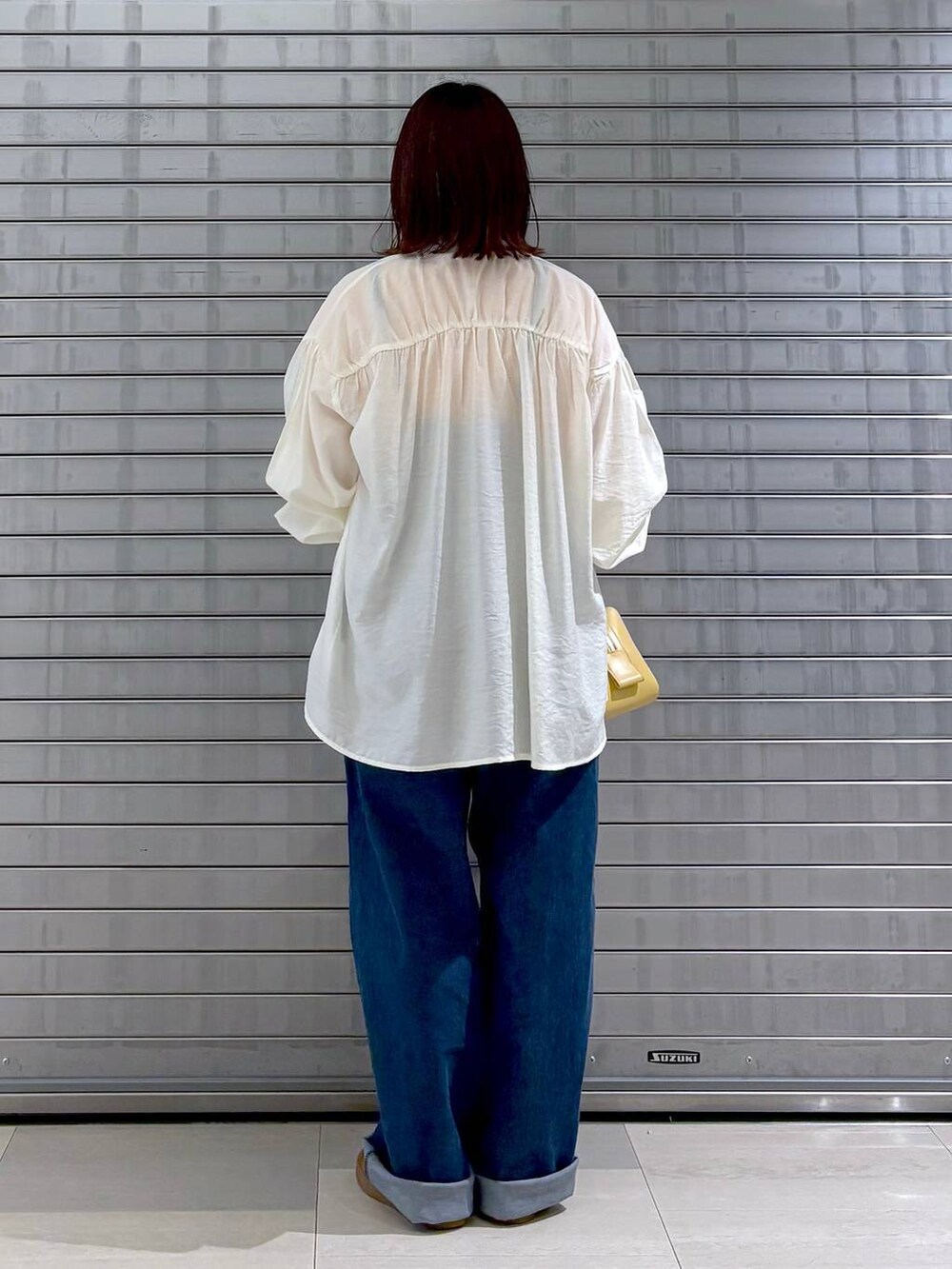 ブルー系のサロペット/オーバーオール、オレンジ系のTシャツ/カットソー、ホワイト系のカーディガン/ボレロを着用したレディースの秋コーディネートの6枚目の写真