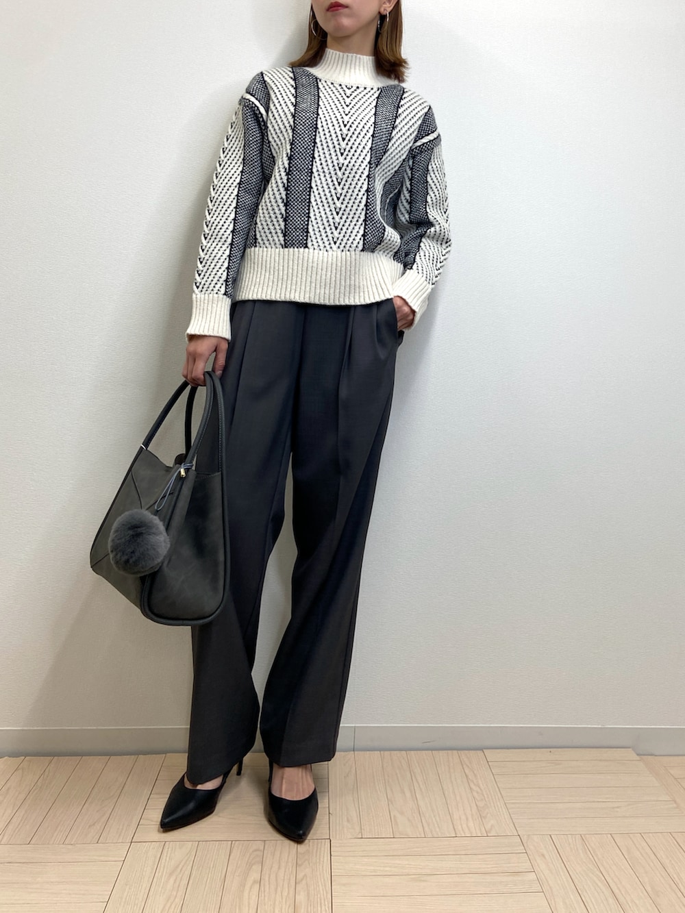 ホワイト系のニット/セーター、グレー系のその他パンツ、グレー系のバッグを着用したレディースの冬コーディネートの2枚目の写真