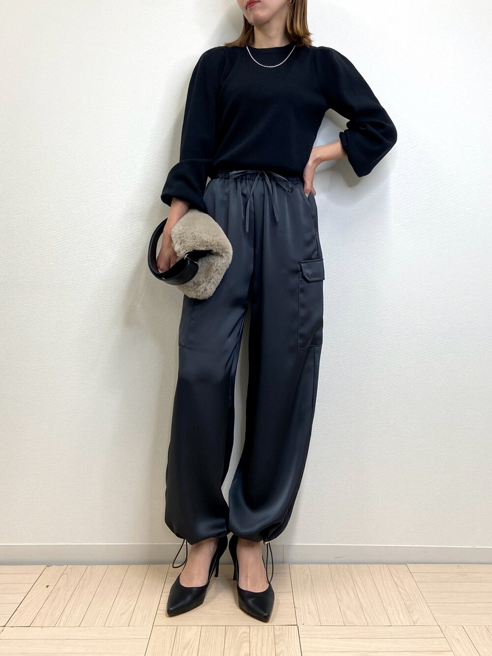 ブラック系のニット/セーター、グレー系のカーゴパンツ、グレー系のバッグを着用したレディースの冬コーディネートの2枚目の写真