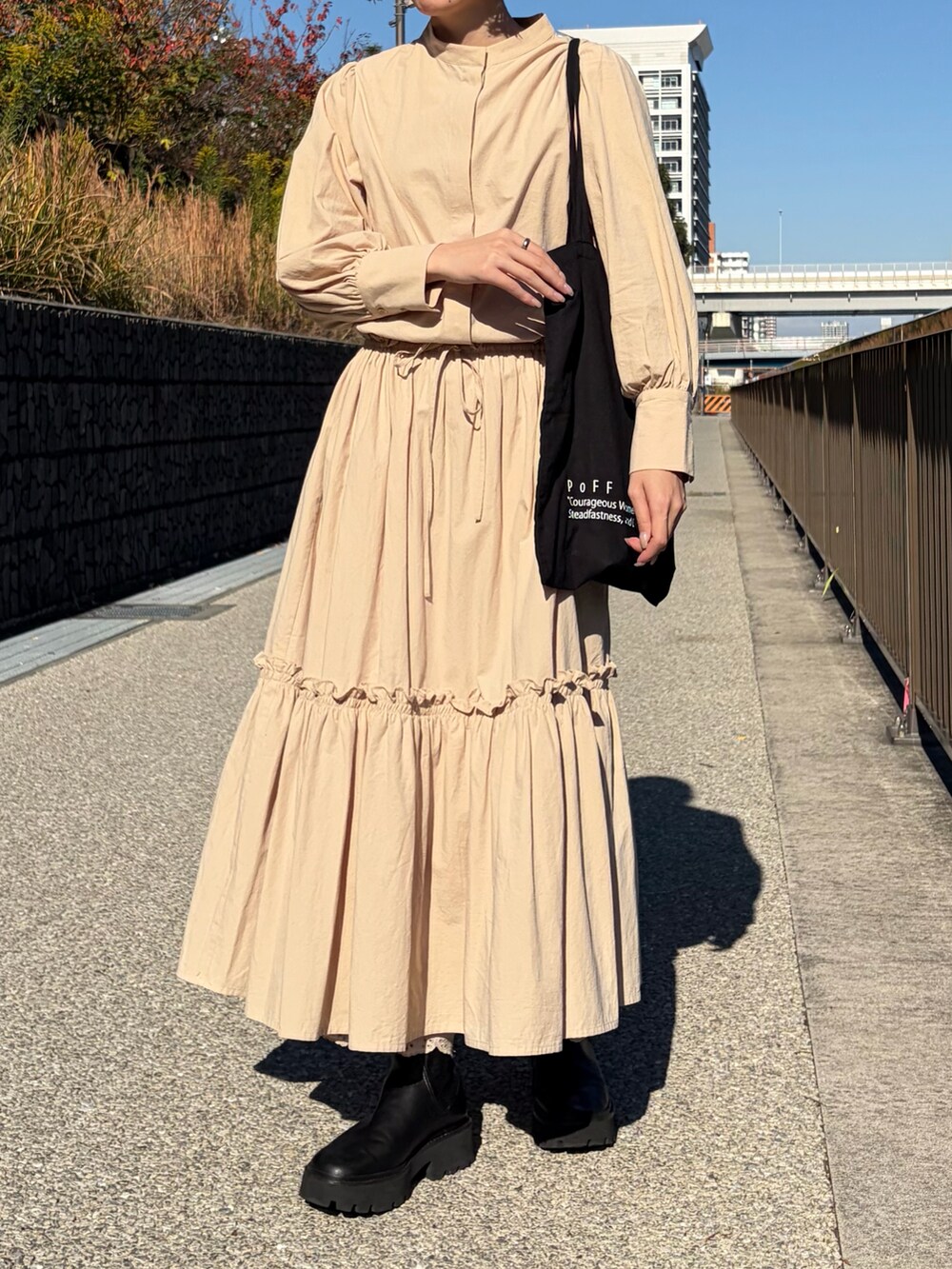 ベージュ系のワンピースを着用したレディースの春コーディネートの2枚目の写真