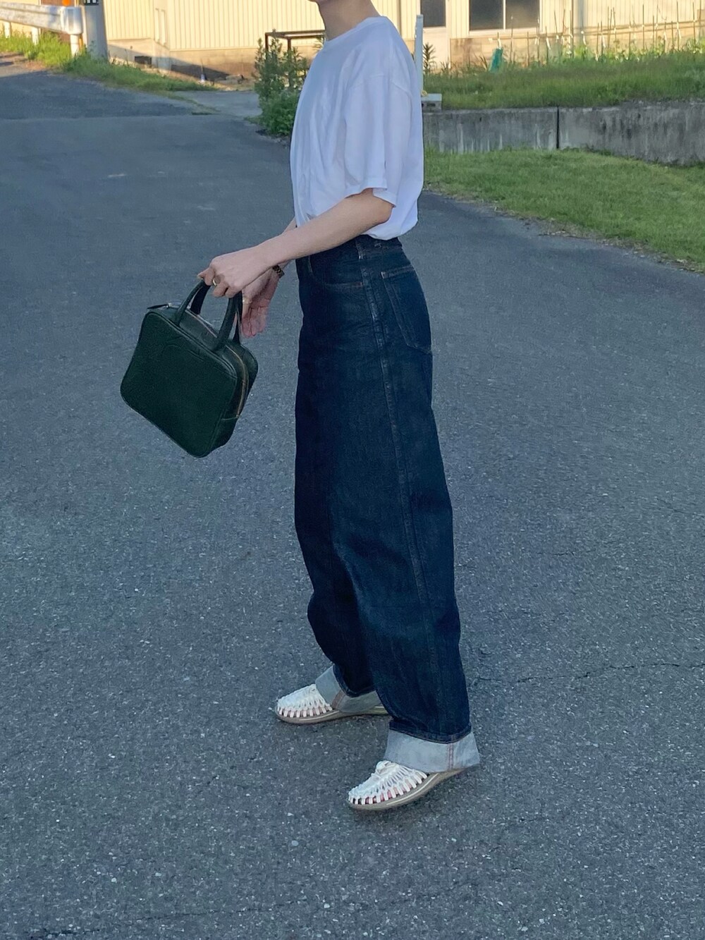 ホワイト系のサンダル、ブルー系のハンドバッグ、ホワイト系のTシャツ/カットソーを着用したレディースの夏コーディネートの2枚目の写真