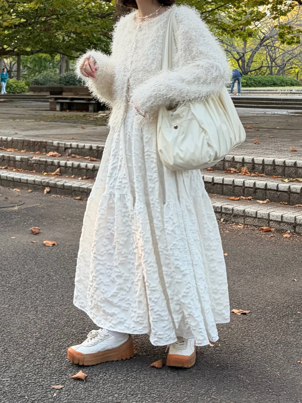 ホワイト系のカーディガン/ボレロ、ホワイト系のトートバッグ、ホワイト系のスカートを着用したレディースの春コーディネートの2枚目の写真