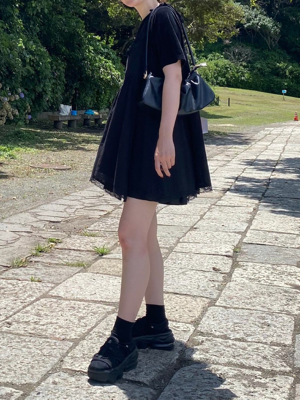 ブラック系のサンダル、ブラック系のトートバッグを着用したレディースの夏コーディネートの2枚目の写真