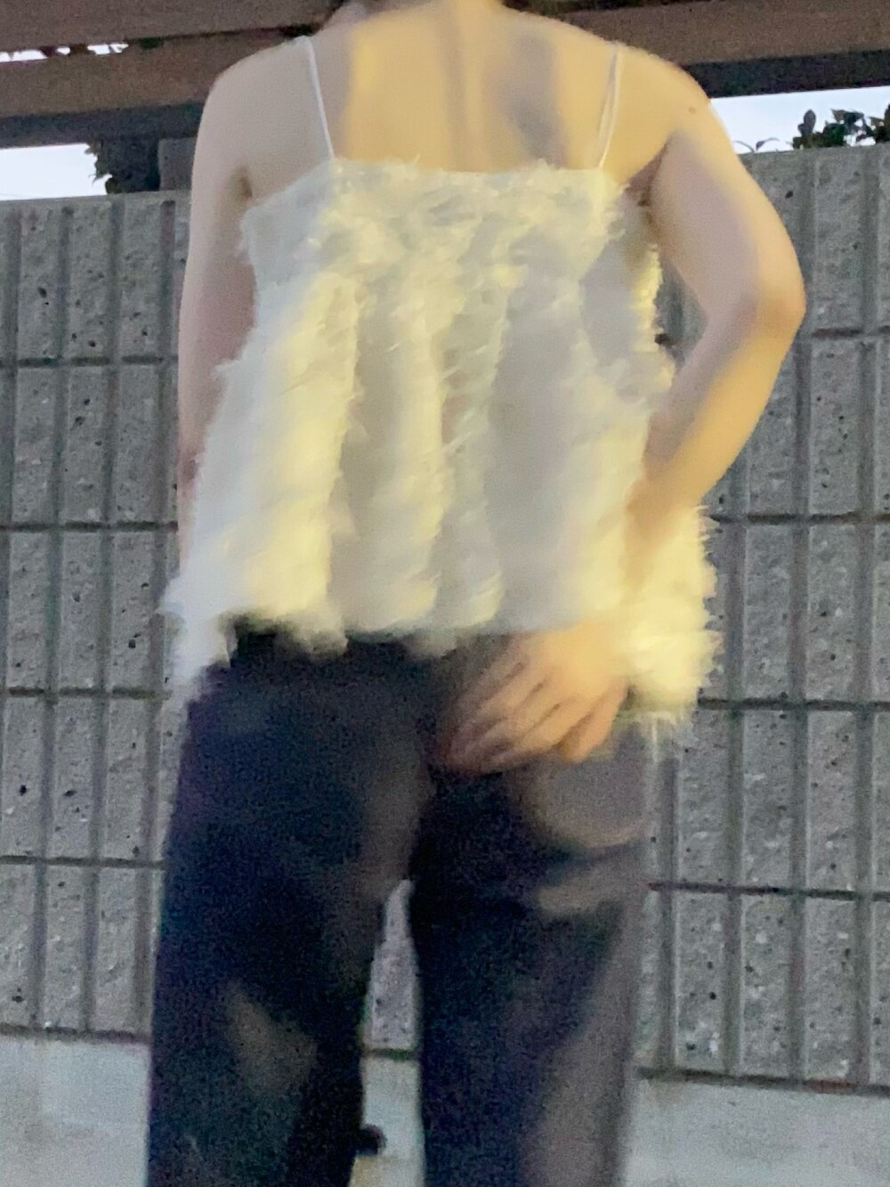 ブルー系のデニムパンツ、ホワイト系のキャミソール、ブラック系のサンダルを着用したレディースの秋コーディネートの2枚目の写真