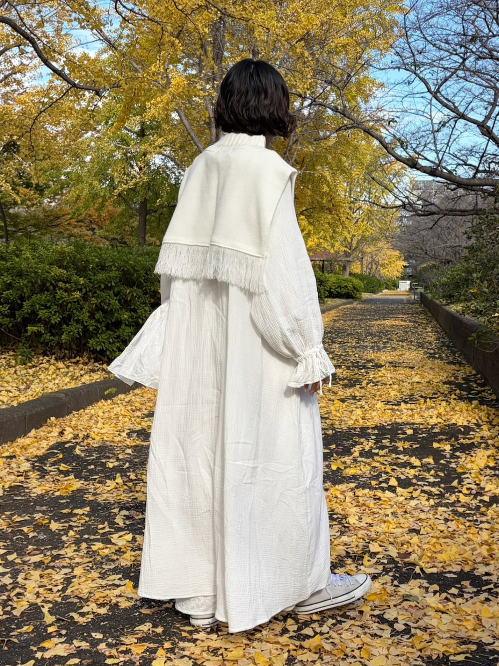 ホワイト系のワンピース、ホワイト系のベストを着用したレディースの春コーディネートの2枚目の写真