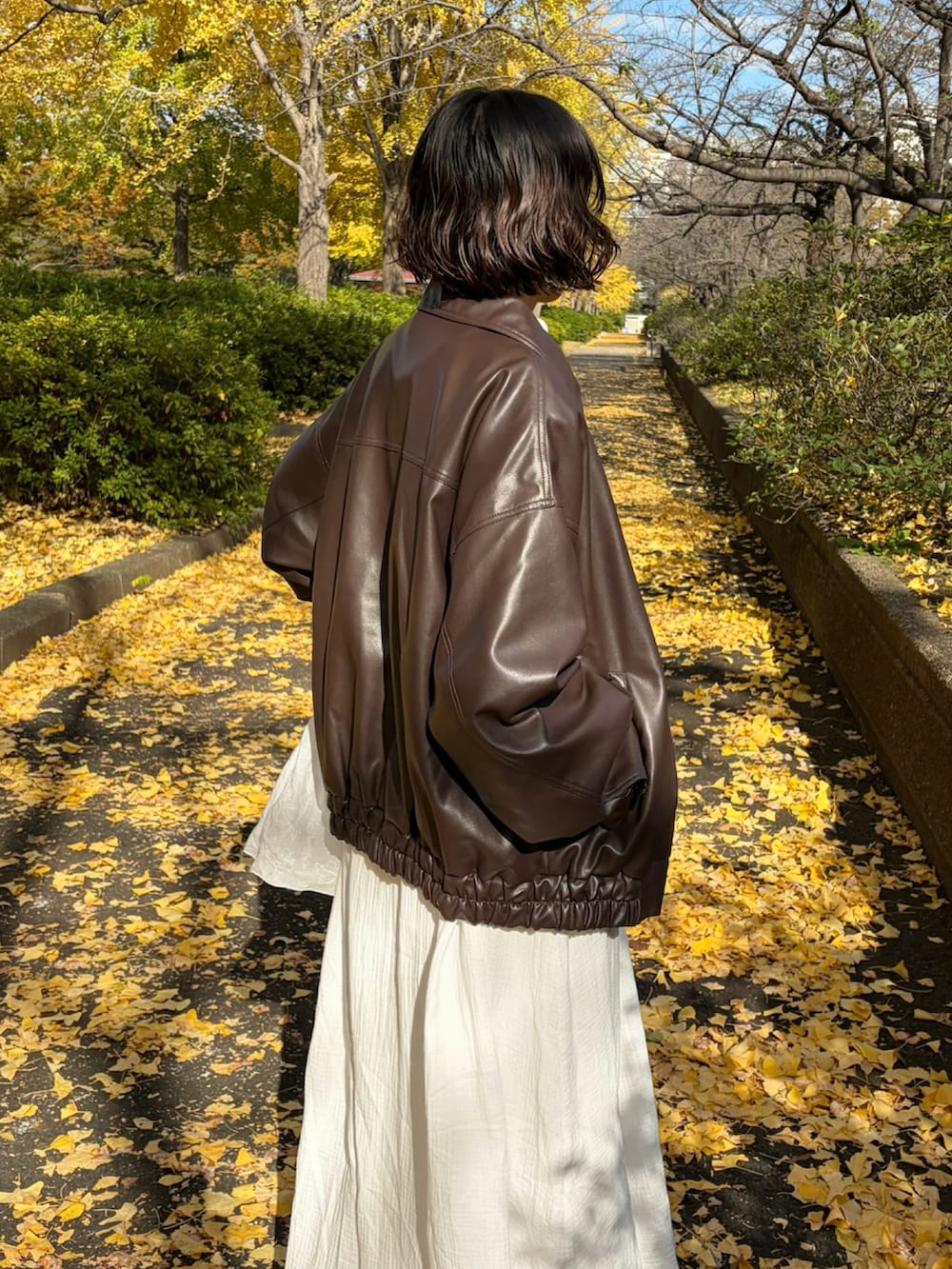 ホワイト系のワンピース、ホワイト系のベストを着用したレディースの春コーディネートの3枚目の写真