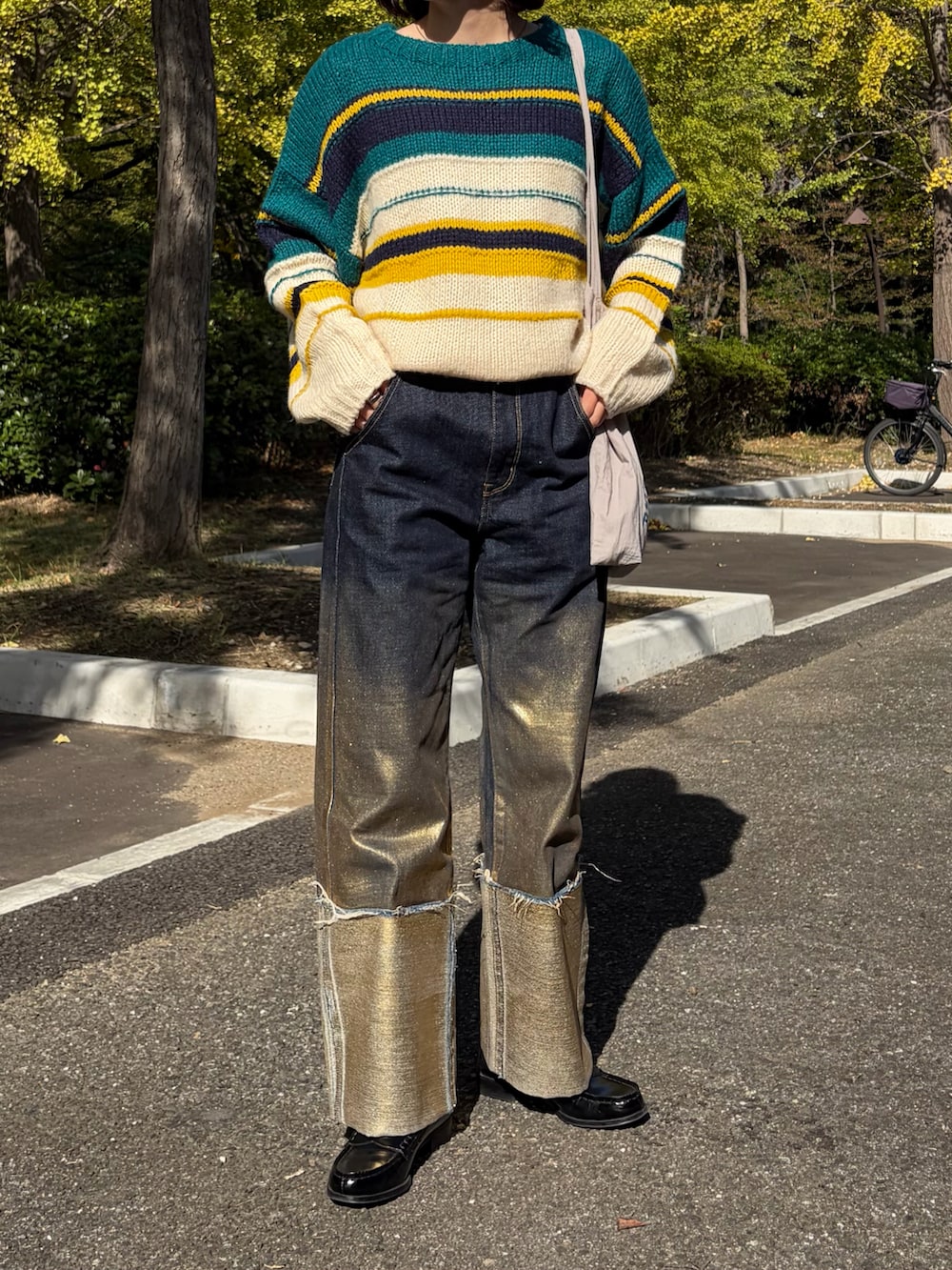 ブラック系のローファー、ブルー系のデニムパンツを着用したレディースの春コーディネートの2枚目の写真