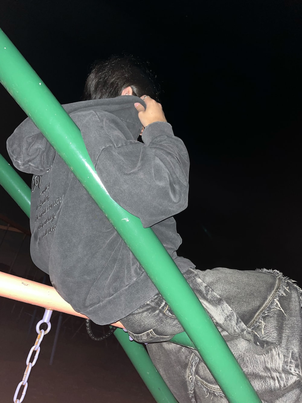 ブラック系のパーカー、ブラック系のデニムパンツ、ブラック系のスニーカーを着用したメンズの秋コーディネートの2枚目の写真