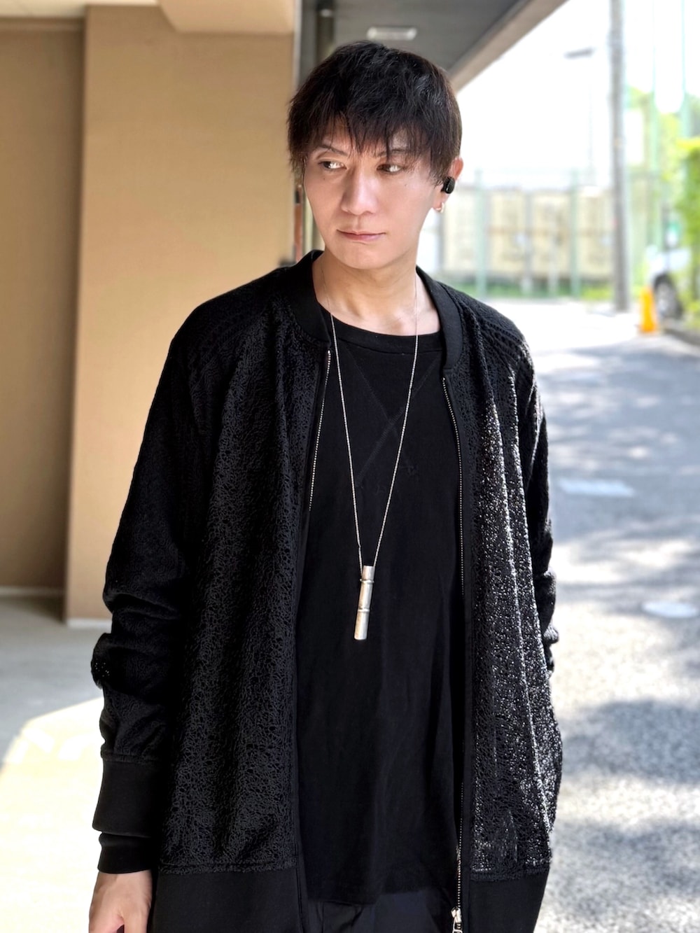 ブラック系のブルゾン、ブラック系のTシャツ/カットソー、ブラック系のトートバッグを着用したメンズの春コーディネートの2枚目の写真