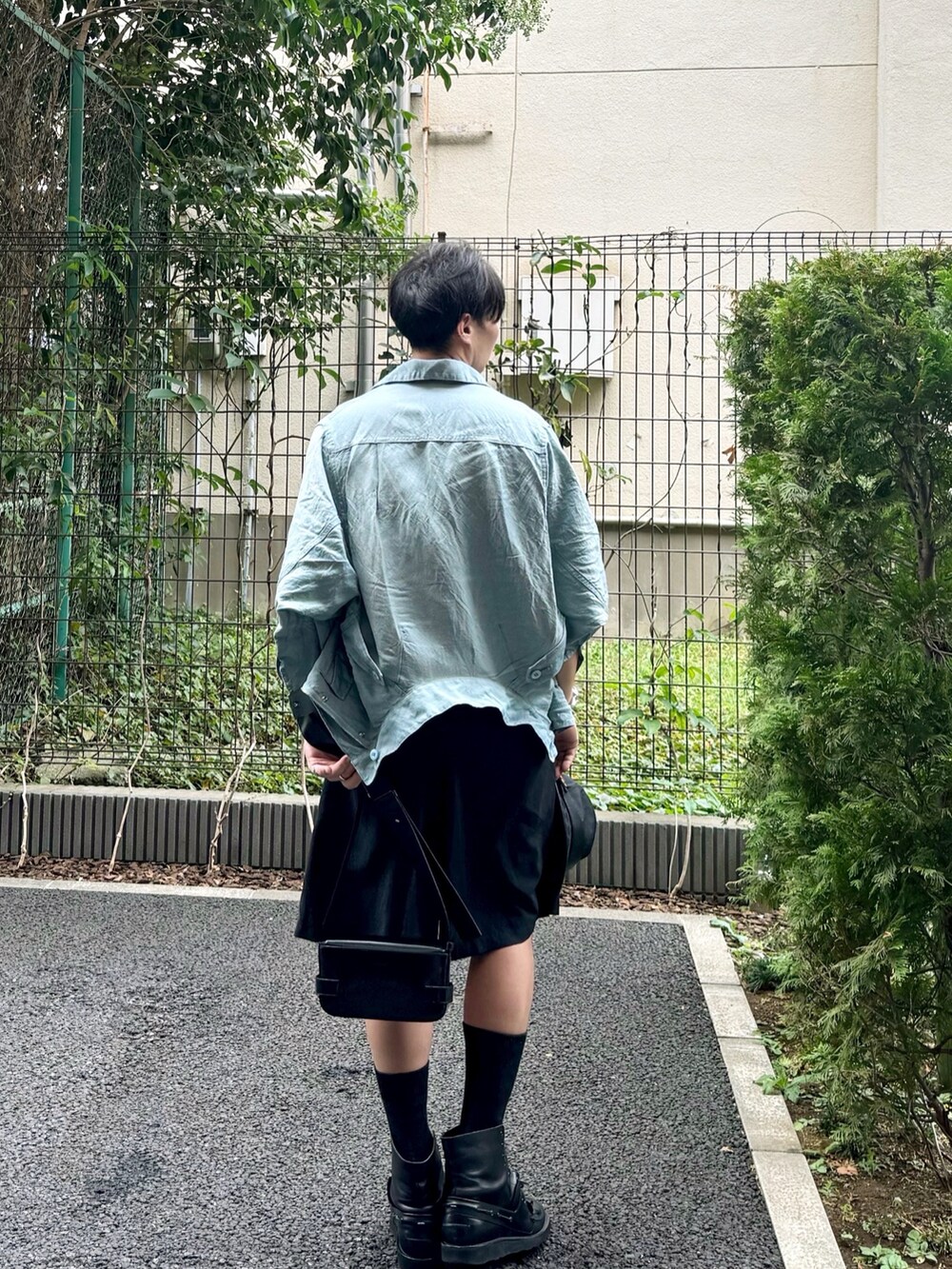 ブルー系のブルゾン、ブラック系のその他パンツ、ブラック系のショルダーバッグを着用したメンズの秋コーディネートの2枚目の写真