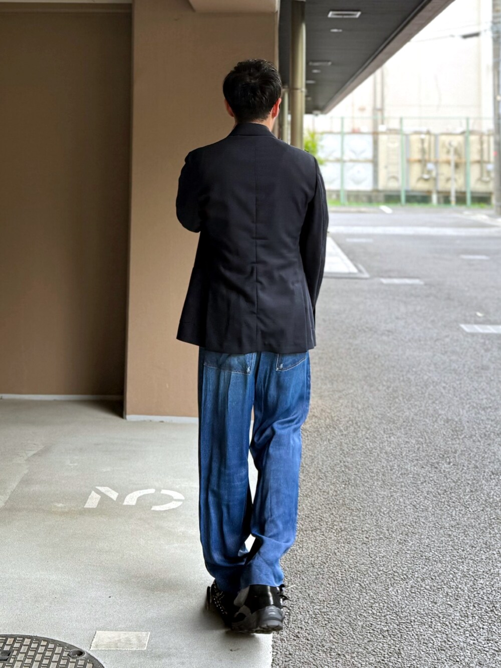 ブルー系のテーラードジャケット、ピンク系のニット/セーター、ブラック系のショルダーバッグを着用したメンズの春コーディネートの2枚目の写真