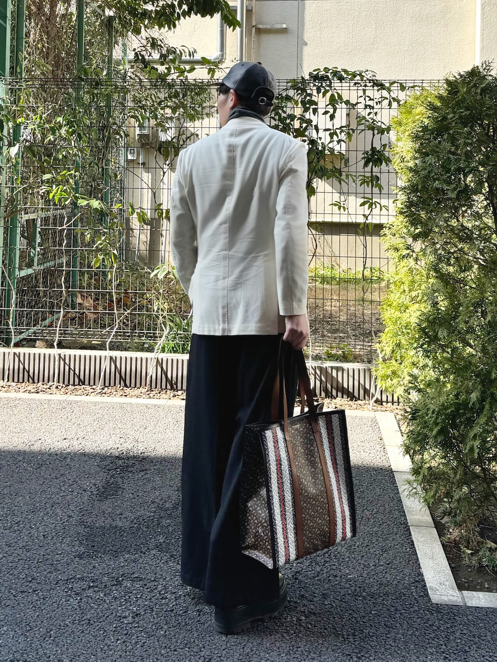 グレー系のTシャツ/カットソー、ホワイト系のテーラードジャケット、ブラック系のスラックスを着用したメンズの冬コーディネートの2枚目の写真